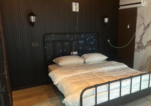 a bed in a bedroom with a black wall at הבקתה בעתיקה in Beer Sheva