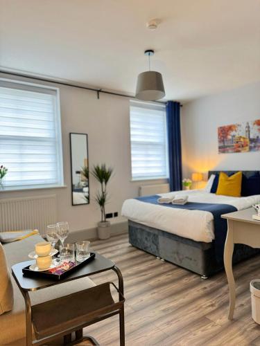a bedroom with a king sized bed and a living room at Camden Luxury Studio Flats and En-Suit Rooms in London