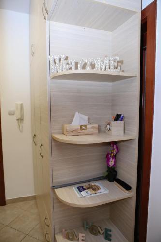 a book shelf with glasses and other items on it at Iva Lux stan na dan in Banja Luka
