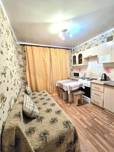 a bedroom with a large bed and a kitchen at Аэропорт Астана 5 минут юг1 582 in Prigorodnyy
