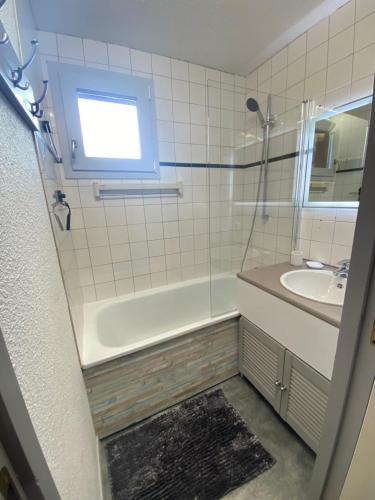 une salle de bain avec une baignoire, un lavabo et une fenêtre dans l'établissement La Casa Di Giuma Magnifique studio à Valmorel, à Valmorel
