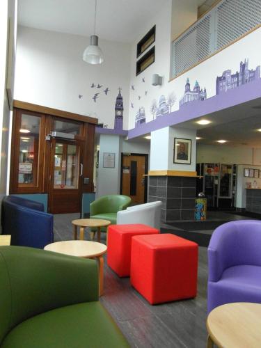 a waiting room with colorful chairs and tables at Belfast International Youth Hostel in Belfast