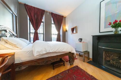 a bedroom with a bed and a fireplace at 2 bedrooms with one private bathroom in lovely home in New York