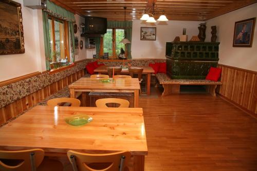 House Berdnik في Stahovica: مطعم بطاولات وكراسي خشبية وأريكة