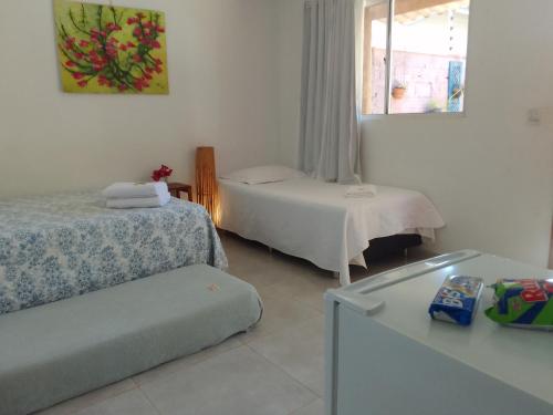 a hotel room with two beds and a window at Pousada Canto das Estrelas in Chapada dos Guimarães