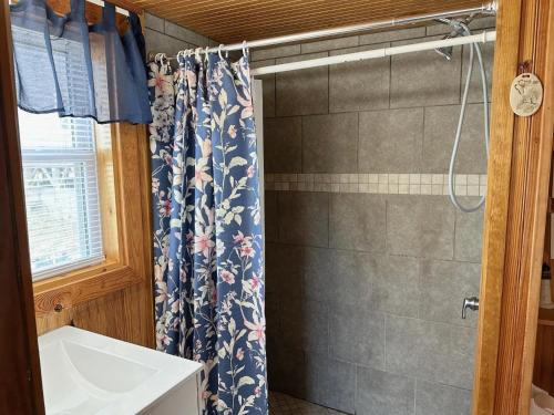 Un baño con cortina de ducha y lavabo. en NH339B Beach Angel, en Nags Head