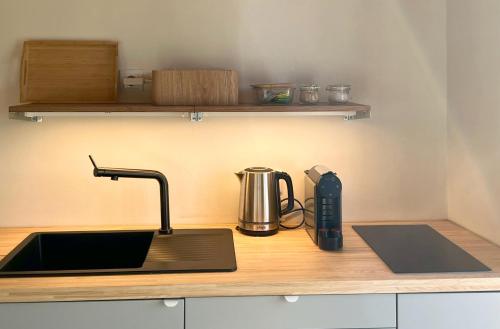 a kitchen counter with a sink and a tea kettle at Casinha do Sol - Natureza & Lazer - Serra da Freita in Arouca