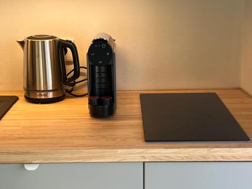a black coffee maker sitting on a counter with a laptop at Casinha do Sol - Natureza & Lazer - Serra da Freita in Arouca
