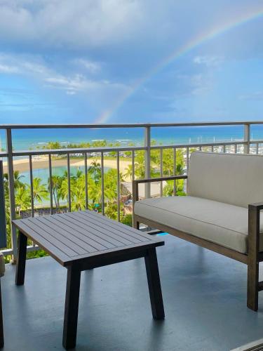 a bench on a balcony with a view of the beach at Panoramic Oceanview Resort - Full Kitchen in Each Unit, 2 Swimming Pools, Onsite Restaurants, Fireworks Every Friday in Honolulu