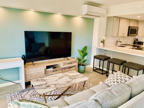 a living room with a couch and a large flat screen tv at Panoramic Oceanview Resort - Full Kitchen in Each Unit, 2 Swimming Pools, Onsite Restaurants, Fireworks Every Friday in Honolulu