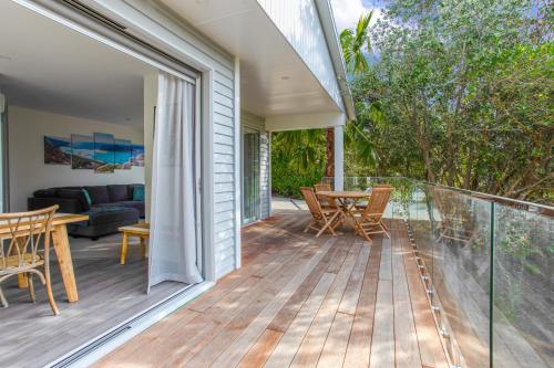 a deck with a table and chairs on a house at Red Beach Hideaway with BBQ and Air-con in Red Beach