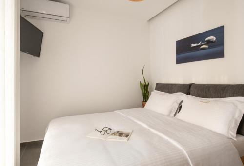 a bed with a pair of glasses and a book on it at Prive Studio in Thessaloniki