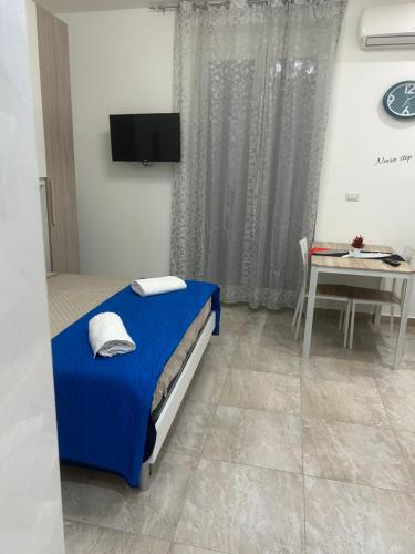 a bedroom with a blue bed and a table at San Donato Apartment in Barletta