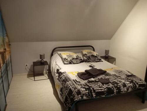 une chambre avec un lit avec une couette noire et blanche dans l'établissement Cottage champêtre, à Marmoutier