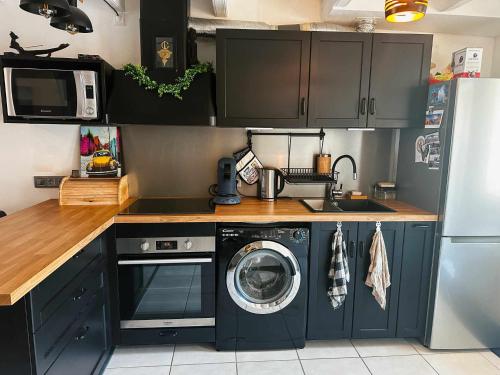 une cuisine avec un lave-linge et un lave-linge dans l'établissement Nid sous le volcan - Maison avec jardins, à Saint-Sandoux