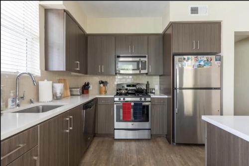 a kitchen with stainless steel appliances and wooden cabinets at Beautiful Getaway Near Venice in Los Angeles