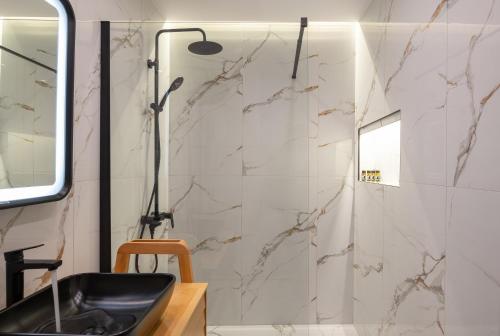 a bathroom with a shower with a black sink at Prive Studio in Thessaloniki