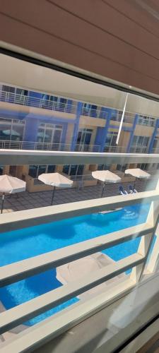 a reflection of a pool with chairs and a building at Hurghada Mirage Bay Hotel & Aquapark in Hurghada