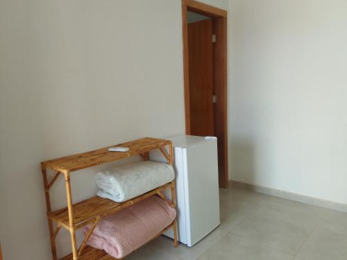 a room with a shelf with towels and a refrigerator at Pousada Canto das Estrelas in Chapada dos Guimarães
