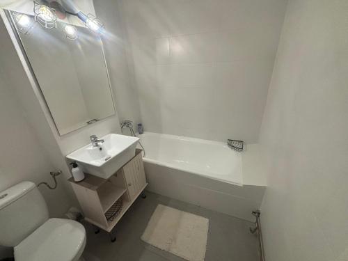 a white bathroom with a sink and a toilet at Apartament City Center Craiova in Craiova