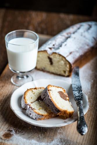 a plate with a slice of bread and a glass of milk at Conacul Archia in Deva