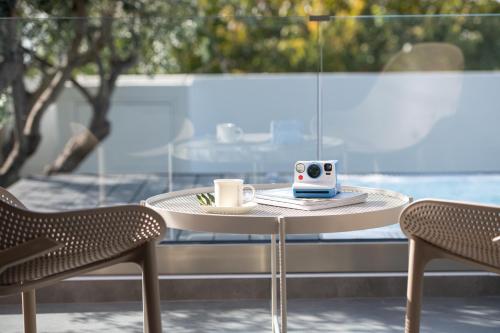 a table with a coffee mug and two chairs at Prive Studio in Thessaloniki