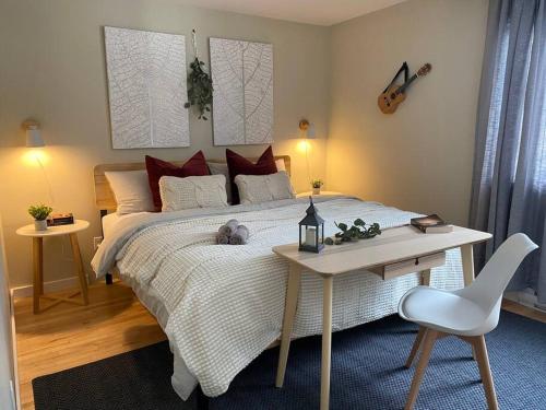 a bedroom with a bed and a table and a guitar at Cozy Riverside Cottage Escape with SPA, Pool Table and Dock Access in Rigaud