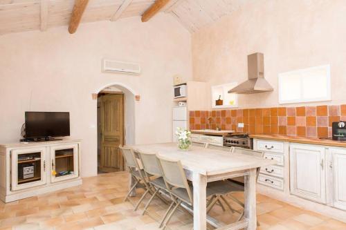 une cuisine avec une table et des chaises dans une pièce dans l'établissement La bergerie des pins, à La Roquette-sur-Siagne