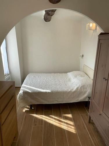- une chambre avec un lit dans une pièce avec une arche dans l'établissement Le nid douillet au cœur du village, à Sainte-Agnès