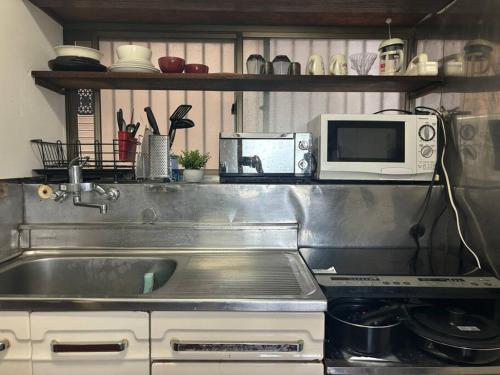 a kitchen with a sink and a microwave at Japanese house -Vacation stay- in Saitama