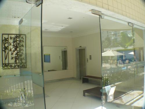 a lobby with a glass wall and a table and bench at Dolce Vita Residence in Rio de Janeiro