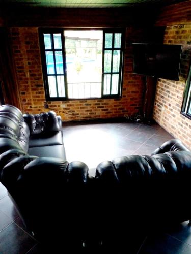 a black leather couch in a room with a window at Mi Ranchito Alojamiento Familiar in Calarcá