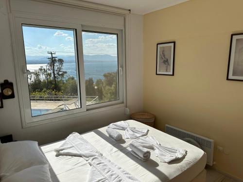 a bedroom with a bed and a large window at Endless Blue in Loutraki