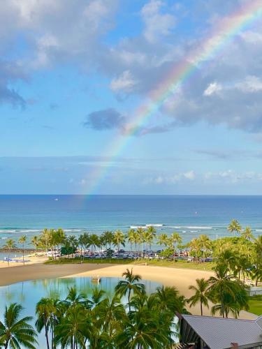 a rainbow over the beach and the ocean at Panoramic Oceanview Resort - Full Kitchen in Each Unit, 2 Swimming Pools, Onsite Restaurants, Fireworks Every Friday in Honolulu