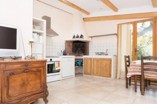 une cuisine avec une table et une télévision sur un comptoir dans l'établissement La petite maison des pins, à La Roquette-sur-Siagne