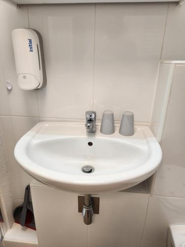 a bathroom sink with two mugs on top of it at Stuttgart City Apartment B in Stuttgart
