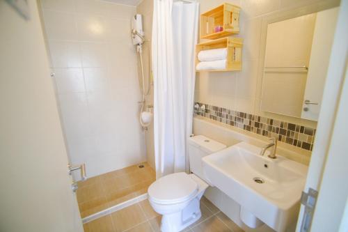 a bathroom with a white toilet and a sink at Baan Thew Lom @ Sea in Cha Am