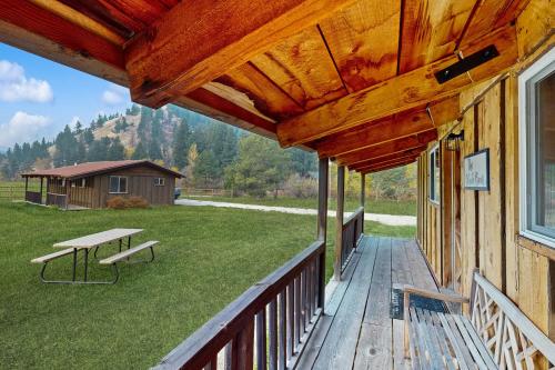 a porch of a house with a picnic table on it at Broad Axe - Cabin #2 - Black Bear in Sula