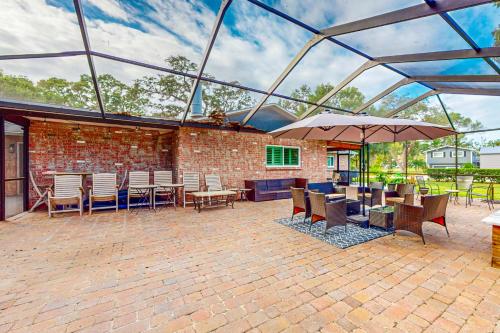a patio with tables and chairs and an umbrella at Crystal Palms in Palm Harbor