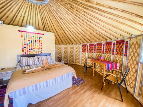 um quarto numa tenda com uma cama e uma mesa em Altos de Quitor, Glamping em San Pedro de Atacama