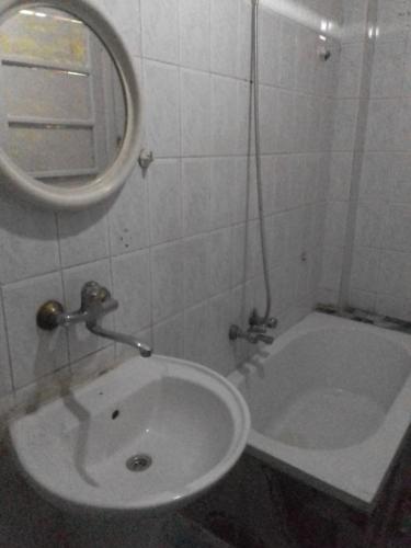 a bathroom with a sink and a mirror and a tub at 35 ادفو علي امين in Alexandria