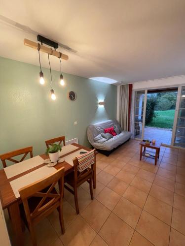 une salle à manger avec une table et un canapé dans l'établissement Séjour 4 personnes - Pays Basque, à Uhart-Cize