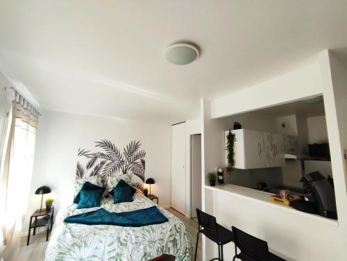 une chambre avec un lit avec des oreillers bleus dans l'établissement Nuit au Cœur de Bailly, à Bailly-Romainvilliers