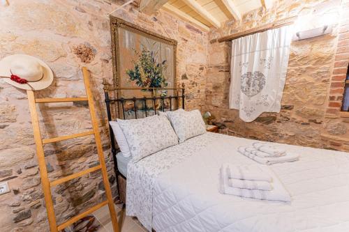 a bedroom with a bed in a stone wall at Irene's Mansion in Vrontados