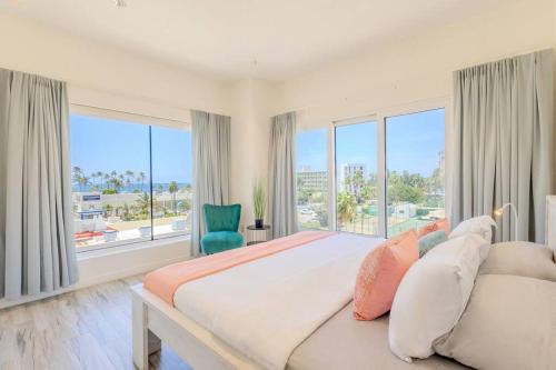 - une grande chambre avec un grand lit et de grandes fenêtres dans l'établissement Luxury Ocean Views Condo in Palm Beach, à Palm-Eagle Beach