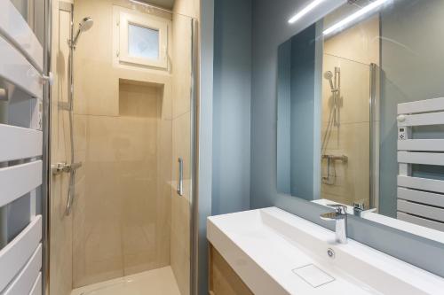 une salle de bain avec une douche, un lavabo et un miroir dans l'établissement La belle vie à 7 minutes à pied du Stade de France, à Saint-Denis