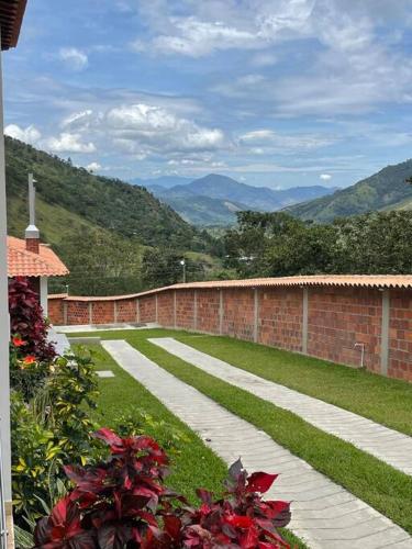 a brick wall and a walkway with mountains in the background at Mansión en chinacota in Chinácota