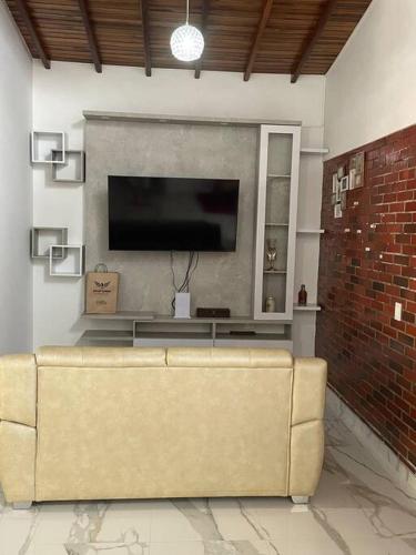 a couch in a living room with a flat screen tv at Mansión en chinacota in Chinácota