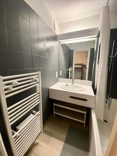 une salle de bain avec un lavabo et un miroir dans l'établissement Résidence Le Cairn - Coquet studio 4 personnes MAE-6741, aux Orres