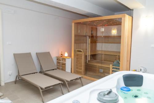 a bathroom with two chairs and a bath tub at Hotel Alexander & Spa in Sanremo
